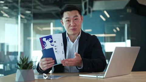 Manager sitting at desktop and holding tickets while telling details about trips Stock-Footage 271021787