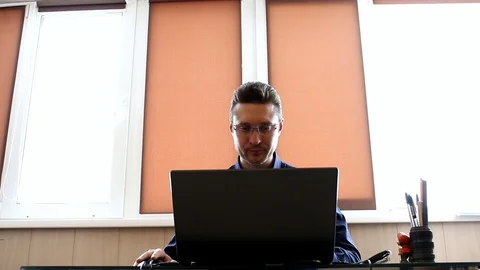 Manager smiling at the computer. Businessman laughing Stock Footage 87790586