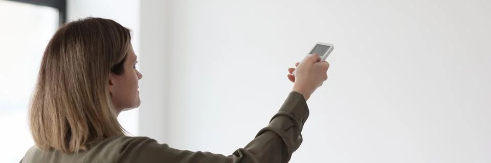 Manager stabilizes temperature in office with remote control Stock Photos