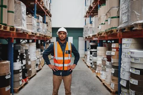 Manager standing in warehouse between shelf filled with goods wearing a white Stock Photos