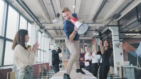 Manager start to dance on the table, sings into a megaphone, accelerates and Stock Footage 108378234