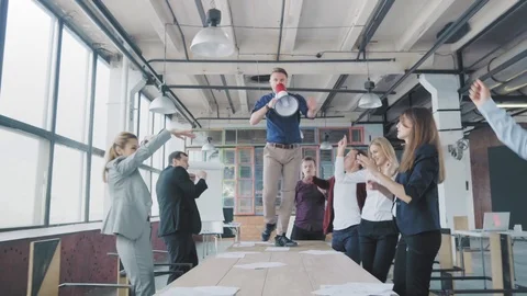 Manager start to dance on the table, sings into a megaphone, accelerates and Stock Footage 108675522