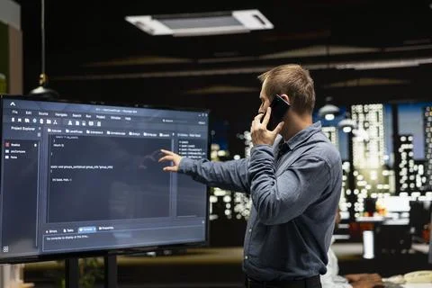 Manager in startup office calling IT workers after noticing error in code Foto stock