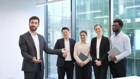 Manager in a suit invites to join the team businesspeople standing in modern  Stock Footage 322222030