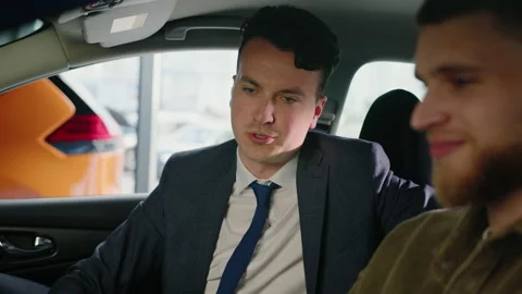 Manager in a suit who talks about new functions in the car Stock Footage 203770537