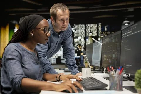 Manager supervising intern in startup office coding machine learning models Stock Photos
