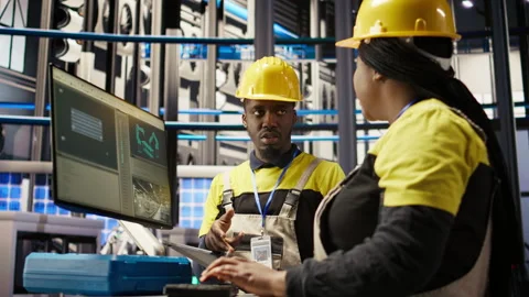 Manager supervising technician in factory using PC to diagnose malfunctions Stock Footage 307367625
