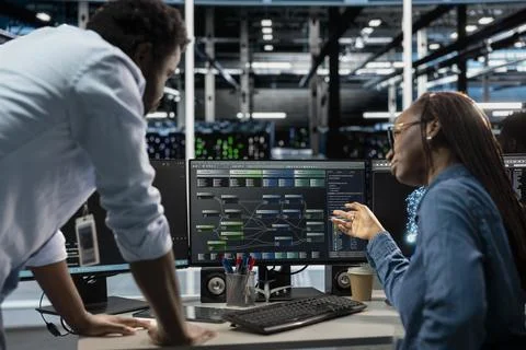 Manager supervising technician programming in server farm 스톡 사진