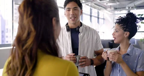 Manager swiping tablet, explaining key points with diverse coworkers at windows Stock Footage 337932730