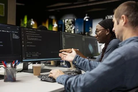 Manager teaching intern to use AI to optimize performance Stock Photos