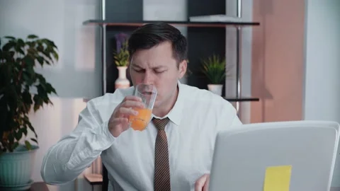 The manager turns on the computer and starts browsing the news while sipping Video stock 146707244