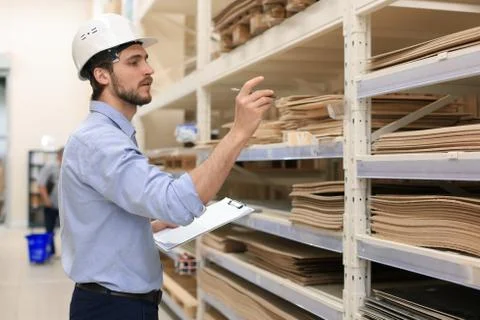 Manager use his tablet for online checking products available. Stock Photos