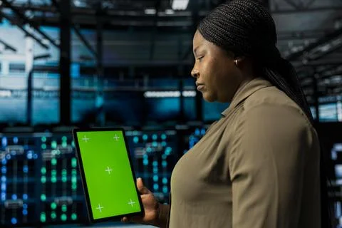 Manager uses isolated screen tablet to do checkup on data center electronics Stock Photos