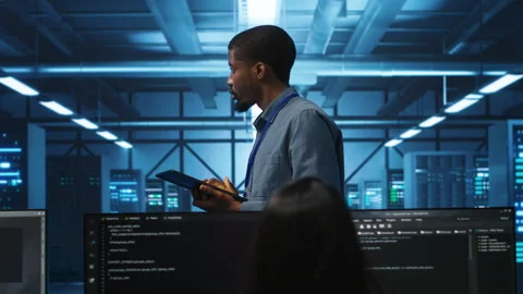Manager uses tablet, supervising team programming in data center Stock Footage 276194460