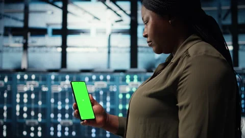 Manager using app on chroma key phone to check server farm energy consumption Stock Footage 317123949