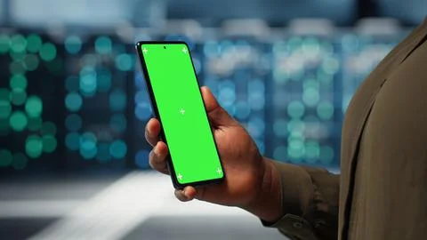 Manager using app on chroma key phone to check server farm energy consumption Stock Photos