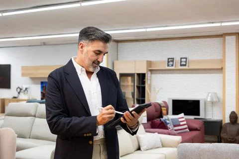 Manager using tablet checking inventory in furniture store showroom 스톡 사진