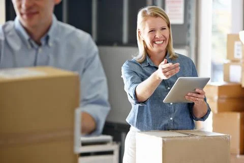 Manager using tablet computer in distribution warehouse 写真素材