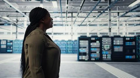 Manager walking in data center, overseeing large scale IT hardware Stock Photos