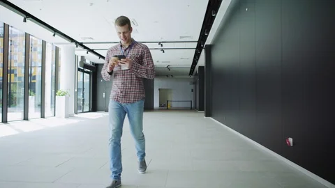 Manager walking in hall and texting on phone Stock Footage 112050755