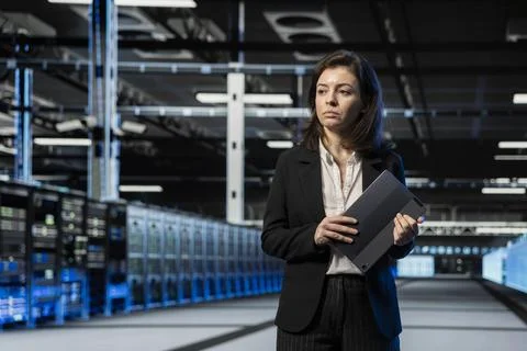 Manager walking through server hub rows, inspecting infrastructure Foto stock
