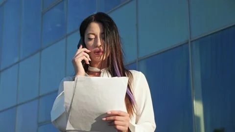 Manager walks talking on phone and looking at documents Video stock 201987121