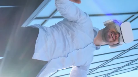 Manager wearing VR glasses, moving his hands in the air. Office worker uses Stock Footage 250029451