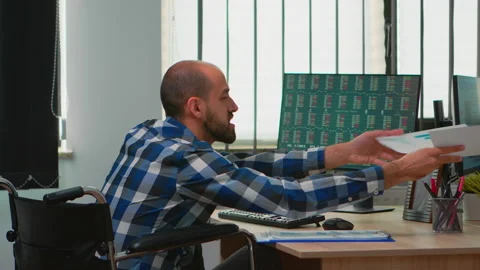 Manager in wheelchair comparing financial data from documents Stock Footage 143184157