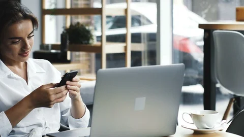 Manager working in cafe with laptop and using phone on break Stock Footage 117133682