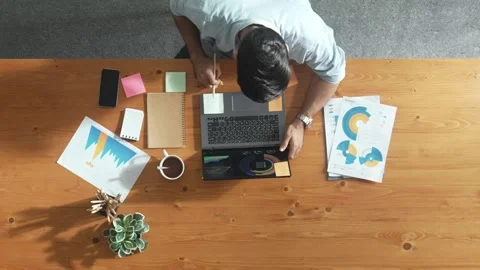Manager working on laptop with team walking and sitting at table. Convocation. Stock Footage 269210639