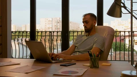 Manager working late in an office lit by warm sunset light Stock Footage 114314058