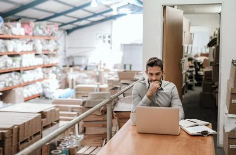 Manager working online while sitting in a warehouse office Stock Photos