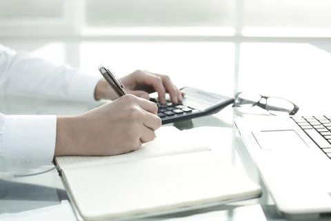 The manager works in the office, keeps notes in a notebook and counts on a Stock Photos