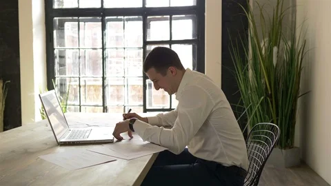 The manager works at the table opposite the window Stock Footage 110938450