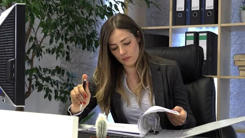 The manager writes on the computer and checks the documentation at the table. Stock Footage 108387170