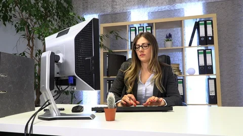 The manager writes on the computer and checks the documentation at the table. Stock-Footage 108425088