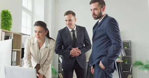 Managers and colleagues review data on computer during office strategy meeting Stock Footage 335738386