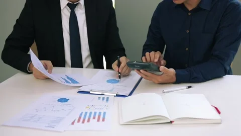 Managers and employees are calculating earnings on paper that contains graph Stock Footage 130304285
