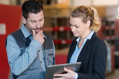 Managers are looking a tablet in a warehouse Stock Photos
