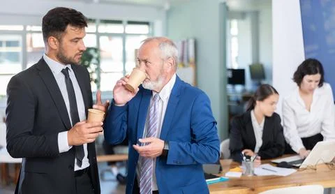 Managers of the bank office discuss work issues during a coffee break Stock Photos