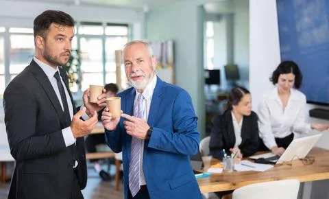 Managers of the bank office discuss work issues during a coffee break Stock Photos