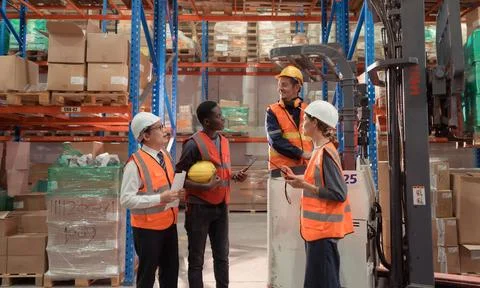Managers, foremen and warehouse workers Consult together about getting the... Stock-Fotos