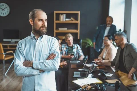 Manager's portrait against backdrop of focused business team working together to Stock Photos