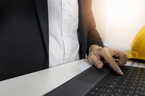 Managers work and type data into project management notebooks. Stock Photos