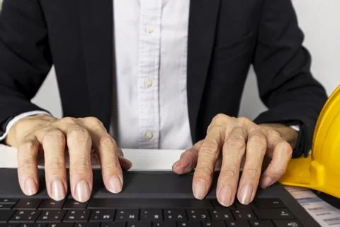 Managers work and type data into project management notebooks. Stock Photos