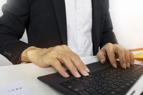 Managers work and type data into project management notebooks. Stock Photos
