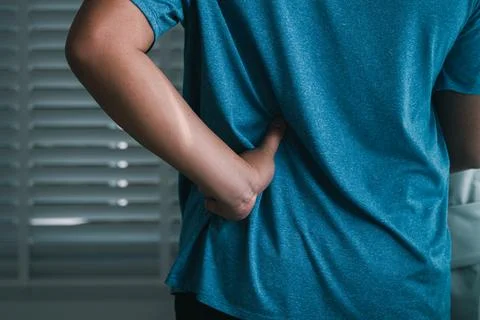 Managing back pain hand techniques for relief at home lifestyle indoor huma.. Stock Photos