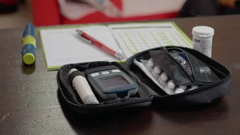 Managing diabetes with a glucometer set, medication, and record keeping Video stock 302423512