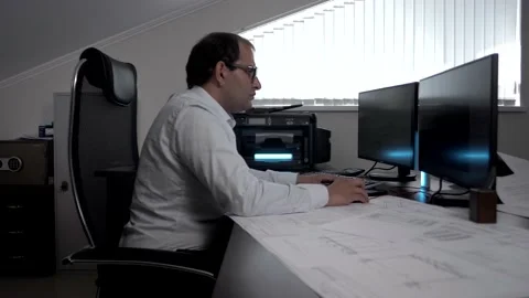 The managing engineer works in the office on his personal computer Stock Footage 135313080