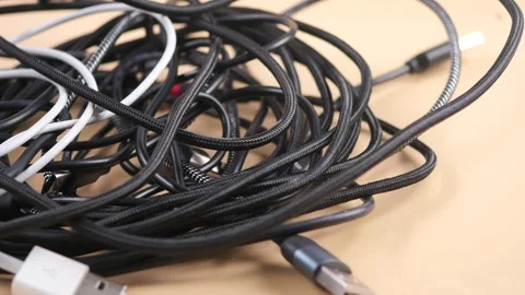 Managing tangled charging cables on a table Stock Footage 330036695